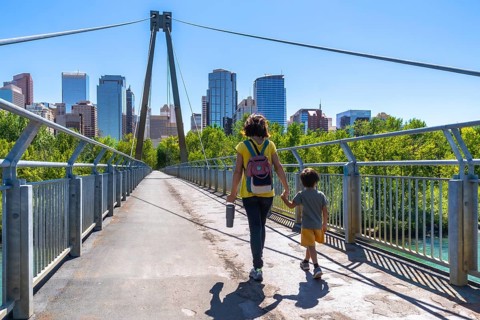 Mother and child are enjoying a leisurely stroll across a pedestrian bridge, set against the