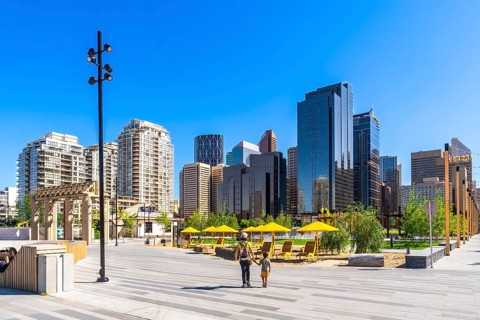 Modern skyscrapers rise above a newly developed urban park in calgary's east village, where a