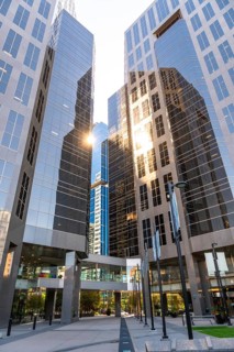 Sun shining through modern glass skyscrapers in calgary, canada, creating a stunning visual effect