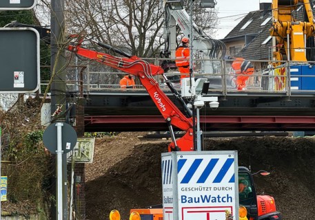 Construction workers with construction machinery on a railway bridge construction site,
