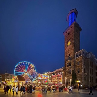 The town hall tower at the Christmas market with the Ferris wheel in the evening, Hagen, Ruhr area,