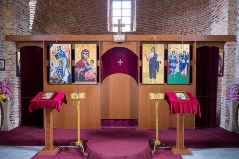 Orthodox iconostasis with richly decorated icons and cross, intricately crafted wood, church,
