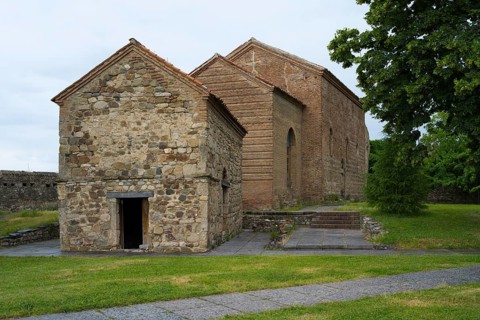 Small stone church with simple construction and rustic charm in a green setting, Batonis Ziche