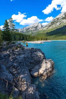 Tourist enjoying the stunning turquoise waters of lake minnewanka, surrounded by the majestic