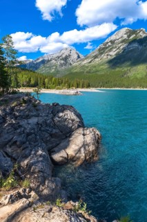 Breathtaking turquoise waters of lake minnewanka reflecting majestic rocky mountains under a