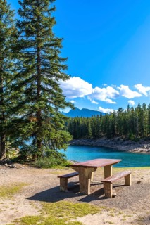 Turquoise waters of lake minnewanka sparkle under a bright blue sky, inviting visitors to enjoy a