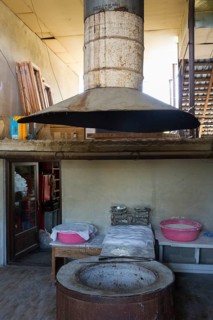 Large traditional oven with extractor hood in a rustic industrial setting, bakery, Badiauri,