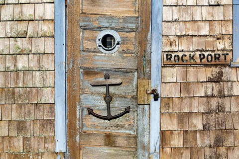 Maritime façade detail in harbor, door with anchor, typical wooden shingles and inscription,