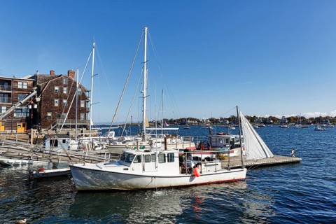 Scenic backdrop, sailboats and historic buildings with shingle façade in harbor, Rockport, Cape