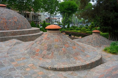 Dome formations and green surroundings with classic brick elements, sulfur baths, Abanotubani spa