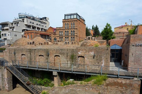 Historic brick buildings with domes in urban surroundings, sulfur baths, Abanotubani spa district,