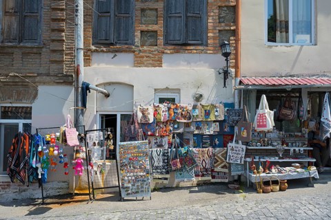 Colourful souvenir stalls along a paved street, decorative pieces and old buildings, Old Town,
