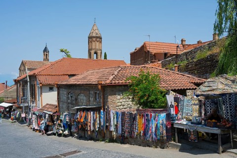 Market scene in an old paved town with colorful fabrics and historic buildings, old town,