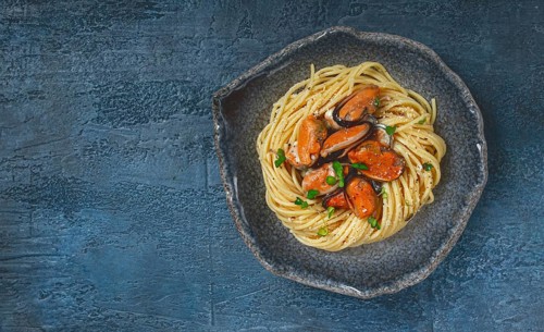 Spaghetti with mussels, without shell, pasta with peeled mussels, in carbonara sauce, micro-greens,