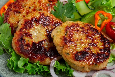 Fried chicken cutlets, minced chicken, with vegetables, on gray, with vegetable salad, top view,
