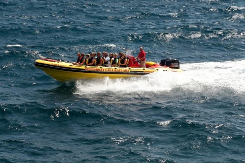 Speedboat speedboat with tourists riding on board glides through waves in the Mediterranean Sea,