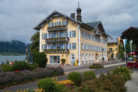 Historic town hall on the banks of Tegernsee, flower decorations in the foreground, town of
