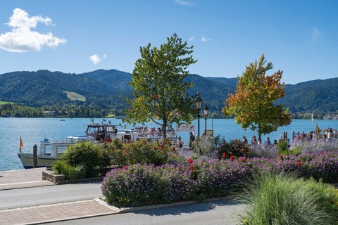 Jetty at Tegernsee, tourists on the promenade, flower beds in the foreground, town of Tegernsee,