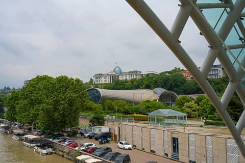 View from the riverbank of modern buildings and dome with boats in the foreground, view from the