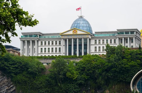 Large government building with dome and flag on a green hill, state palace for ceremonies, Avlabari