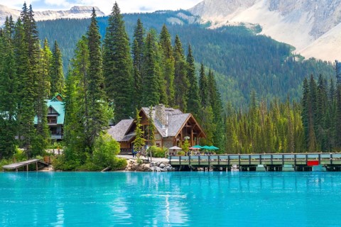 Wooden houses of emerald lake lodge resting on the shore of stunning emerald lake, surrounded by
