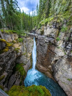 Scenic view of johnston canyon in banff national park, featuring a stunning waterfall cascading