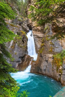 Turquoise water flows through johnston canyon in banff national park, alberta, canada, creating a