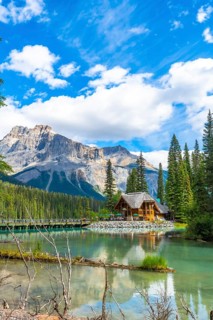 Emerald lake lodge reflecting on turquoise waters, framed by the canadian rockies and pine forest