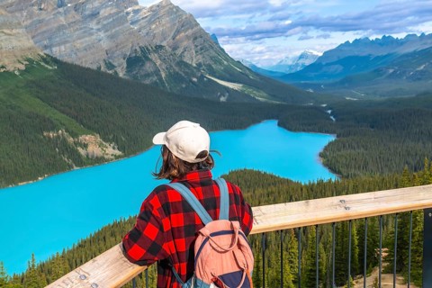 Young hiker enjoying breathtaking view of turquoise peyto lake from a scenic viewpoint in banff