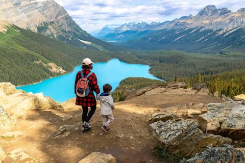 Mother and child admiring the stunning turquoise waters of peyto lake from a scenic viewpoint in