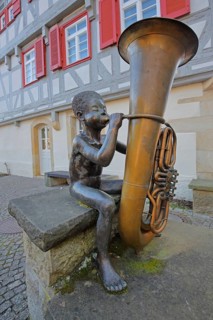 Sculpture boy with tuba by Guido Messer 1991, modern art, bronze sculpture, playing music, tuba,