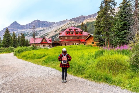Female tourist walking along a gravel path toward the historic num ti jah lodge at bow lake,