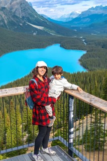 Mother holding her son while admiring the stunning panoramic view of vibrant turquoise waters at