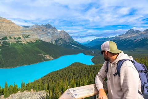 Hiker enjoying breathtaking view of turquoise peyto lake and surrounding canadian rockies mountains