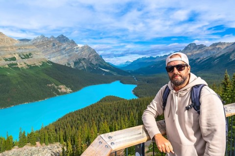 Backpacker standing on a scenic viewpoint, enjoying the stunning turquoise waters of peyto lake and