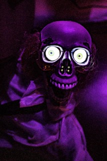 A scary skeleton with glowing eyes in purple lighting in an escape room, Lower Saxony, Germany