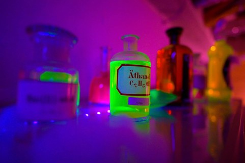 Glowing bottles in an escape room chemical laboratory with neon light create a mystical atmosphere,