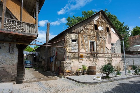 Traditional half-timbered stone house with a veranda in a quiet village street, traditional German