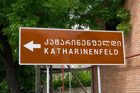 Brown signpost with the name Katharinenfeld, Bolnissi, Katharinenfeld, founded by Caucasian German