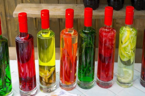 Close-up of colorful bottles filled with pickled fruits, chacha with colorful fruits, vegetables or