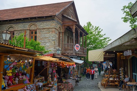 Busy old town street with traditional buildings and market stalls selling souvenirs, Mtskheta,