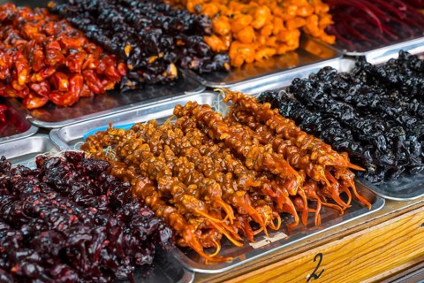 Plates of colorful Georgian sweets made from fruits and nuts at a market stand, Churchkhela,