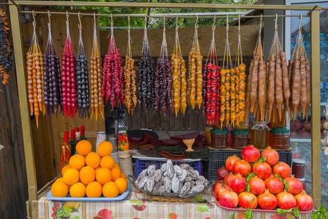 Colourful fruit and candy display with hanging goodies, Churchkhela, Georgian confections,