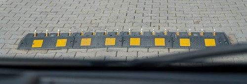 Ground obstruction with yellow markings on a paved road, one-way speed problems with spikes on the