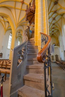 Detailed view of a stone spiral staircase leading to the pulpit with artistic carvings in a church,