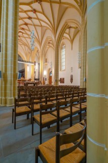 Side view of a large nave with Gothic columns and rows of pews, collegiate church, Herrenberg,