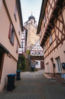 Charming old town street with half-timbered houses and small shops, collegiate church, Herrenberg,