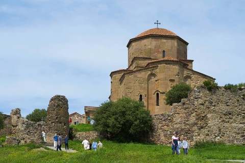 Old church and ruins in green landscape with people outdoors, Javari Monastery, Jvari Monastery,