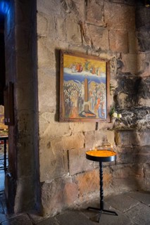 Religious icon on a stone wall with a burning candle in front of it, Javari Monastery, Dzhwari