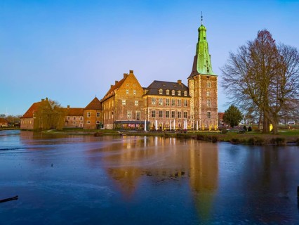 View in winter over partially frozen moat at castle converted into a Renaissance castle today